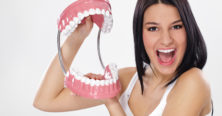 Funny woman holding open jaws, showing healthy teeth
